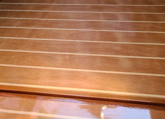 Piso bastonado náutico terminado, con vetas de madera paralelas